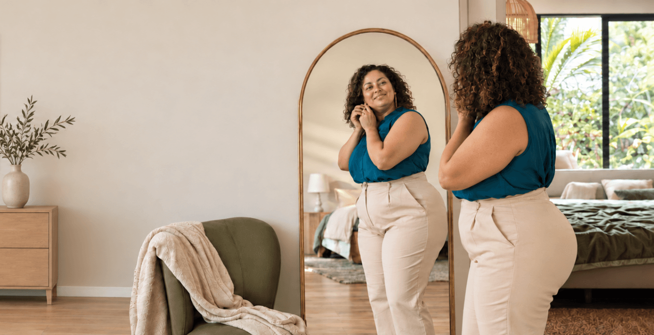 A woman studies herself in the mirror, capturing the private thoughts and feelings that can shape body image and self-worth.